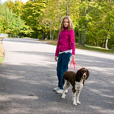 Girl walking dog on leash